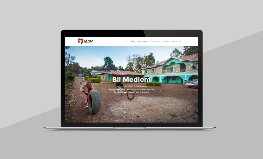 Nettsiden til Kenya Barnehjelp, vist på en macbook med grå bakgrunn